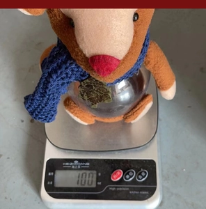 Detail view of a reindeer Christmas candy jar on a scale showing 100g weight