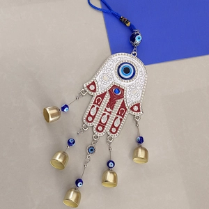 Detailed view of Hamsa Hand ornament featuring blue evil eye beads and metal bells