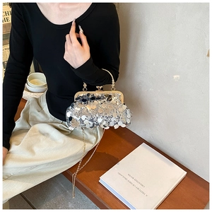 Silver sequin handbag with gold chain strap shown in a vintage interior setting