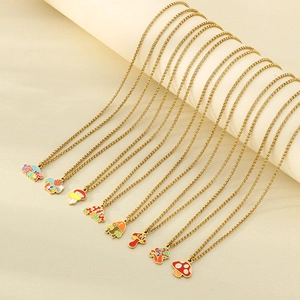 Colorful enamel mushroom pendants on gold chains displayed on minimalist stands