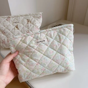 Detail of quilted cosmetic bag with floral puppy print and simple wish woven label