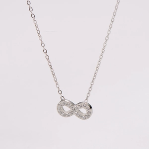 Macro shot of silver infinity pendant necklace featuring sparkling cubic zirconia stones
