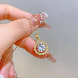 Macro detail of gold-plated circular pendant necklace with sparkling pavé zircons