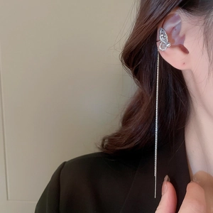 Detail of silver butterfly ear bone clip with long tassel chain and shimmering zircons