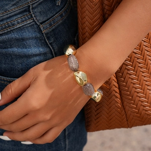 Close-up of bohemian beaded bracelet with gold and brown glitter beads on wrist