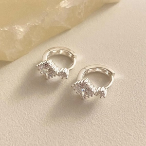 Detail shot of 925 sterling silver hoop earrings with square cubic zirconia and crown setting