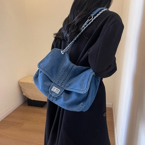 Retro blue denim tote bag with silver chain strap shown in a minimalist indoor setting