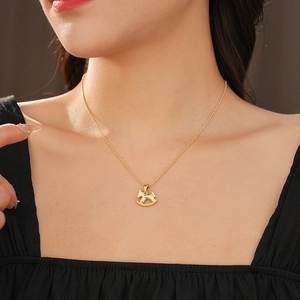 Gros plan du collier avec pendentif cheval à bascule doré sur le cou du mannequin
