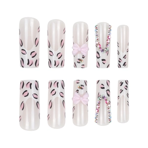 French leopard print press-on nails with 3D pink bows and rhinestone chain accents