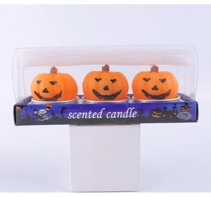 Detailed view of three orange pumpkin scented candles in a Halloween gift box