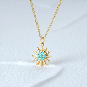 Detail of S925 sterling silver sunburst pendant with turquoise beads on a gold chain