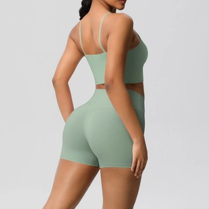 Detail view of seamless high-waisted sage green yoga shorts and strappy sports bra set