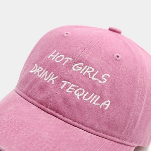 Detail of white letter embroidery on a pink washed cotton baseball cap with eyelets