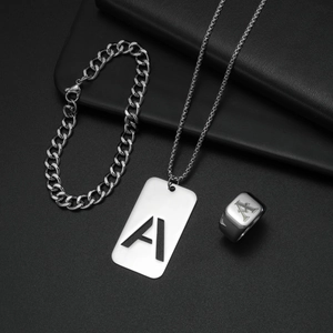 Nahaufnahme eines silbernen Titanstahlschmucksets mit eingraviertem Buchstaben A auf Anhänger