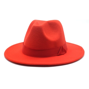 Detail of red wide brim wool fedora hat with matching satin ribbon decoration