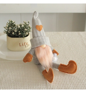 Detail of a Nordic knitted gnome plush with long legs and a pink beard for home decor