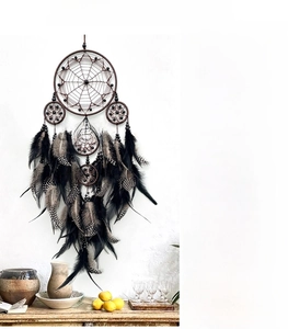 Handmade brown multi-hoop dream catcher with natural black feathers for wall decoration
