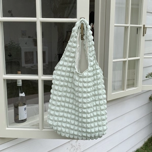 Detail of mint green bubble texture fabric on a large capacity tote shoulder bag