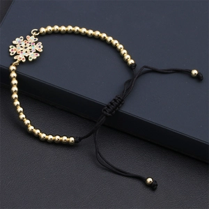 Detail eines verstellbaren Goldperlenarmbands mit buntem Schneeflocken-Zirkonia-Anhänger