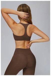 Detail of racerback sports bra and high-waist leggings in coffee brown stretch fabric