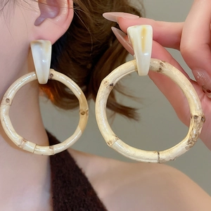 Detailed view of bamboo-textured resin hoop earrings with geometric marble studs