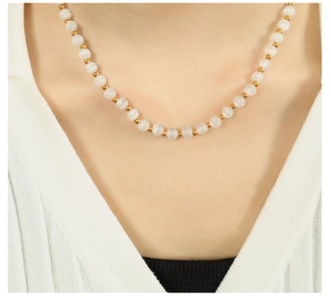 Detailed view of white opal beads and gold metallic spacers on an elegant necklace