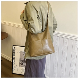 Sac bandoulière chic en PU kaki, vue latérale arrière sur un mannequin en décor épuré