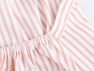 Close-up of pink and white striped fabric with pleated waist detail and soft texture