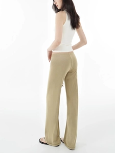 Side view of khaki wide-leg casual pants and white tank top with fluid draping