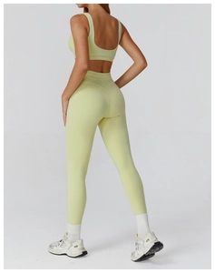 Rear side view showing high-waisted yoga pants and tank top with white piping trim