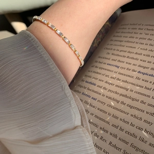 Detailed view of elegant gold tennis bracelet with AAA cubic zirconia on a wrist