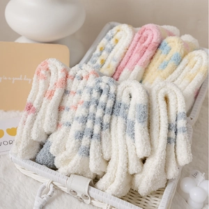 Close-up of soft fuzzy coral fleece socks with colorful stripes in a woven basket
