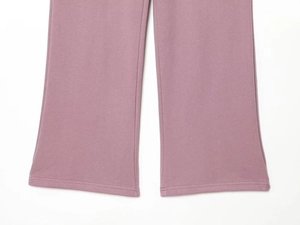 Détail du bas de pantalon en maille rose poudré montrant la texture et l'ourlet fini