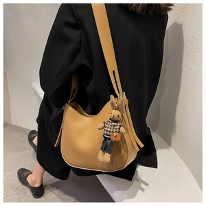 Detail of camel brown PU leather crossbody bag with a cute knitted bunny charm pendant