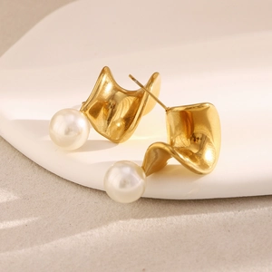 Detailed macro view of 18K gold-plated twisted earrings with white lustrous pearls
