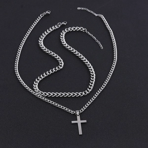 Close-up of double-layer silver stainless steel Cuban chains with a cross pendant