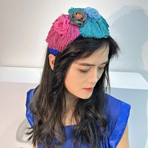 Detail of handmade fabric floral headband with colorful tassels worn by a model