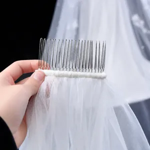 Detail of bridal veil with secure silver metal hair comb and hand-sewn mesh edging
