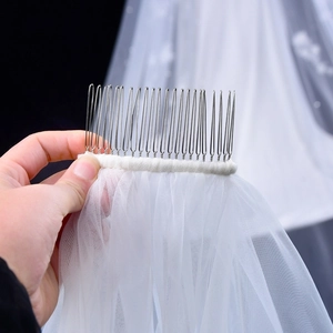 Detail of bridal veil with secure silver metal hair comb and hand-sewn mesh edging