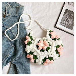 Detail of handmade crochet puff flower bag with pearl clasp and braided strap