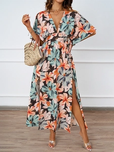 Detail eines hohen Seitenschlitzes an einem Blumen-Maxikleid mit großem orange-blauen Muster