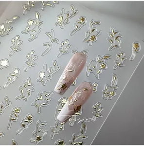 Macro view of gold embossed floral nail art stickers with intricate leaf patterns