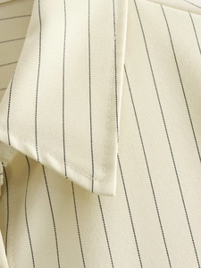 Detailed macro view of high-quality striped twill fabric and fine stitching on shirt collar