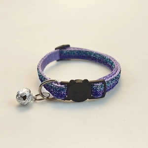 Detailed view of purple glitter cat collar with black cat-shaped buckle and silver bell