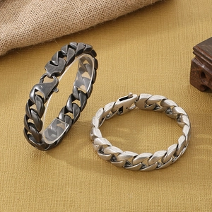 Close-up of retro 15mm silver cuban link steel chain bracelets on a textured background