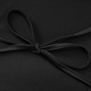 Detailed macro view of the black waist tie knot on this slim-fit fashion dress