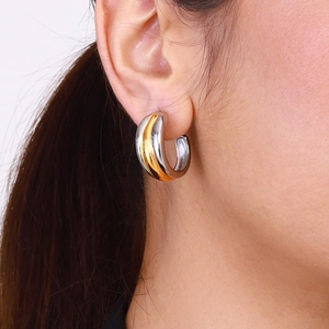 Minimalist two-tone C-shaped stainless steel earrings worn on earlobe for women