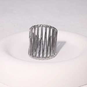 Macro detail of silver wide hollow vertical striped cage ring on white display stand