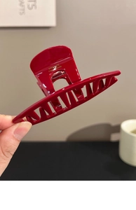 Detail of red acrylic hair claw clip featuring gold France Handmade lettering print