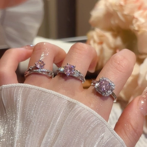 Detail of three luxury silver rings featuring sparkling pink zircon and pavé diamonds
